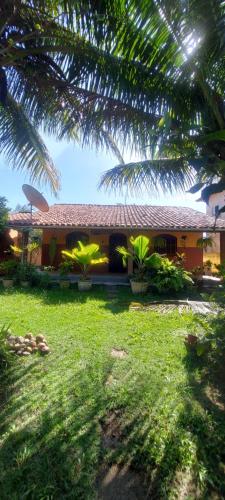 a house with a palm tree in front of it at Aluguel Casa em Praia Seca in Rio de Janeiro