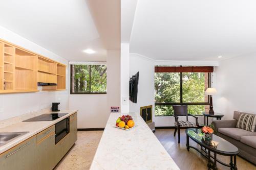 eine Küche und ein Wohnzimmer mit einem Sofa und einem Tisch in der Unterkunft Hotel 101 Park House in Bogotá