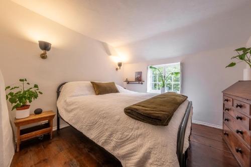 a bedroom with a large bed and a window at Most romantic cottage in Suffolk - Number Four in Framlingham