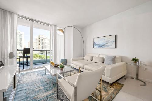 Una sala de estar blanca con un sofá y una mesa. en Luxury 1 BR Condo W Icon Brickell-Waterviews, en Miami