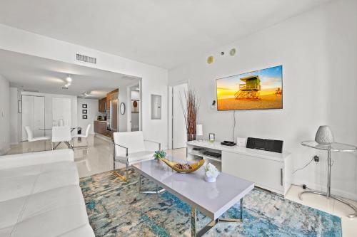 Una sala de estar con un sofá blanco y una mesa. en Luxury 1 BR Condo W Icon Brickell-Waterviews, en Miami