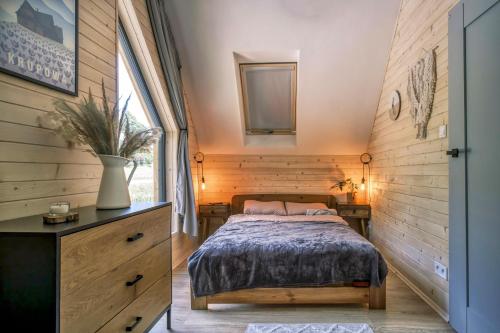1 dormitorio con 1 cama, vestidor y ventana en Babia Ostoja - domek z balią i sauną, en Zawoja