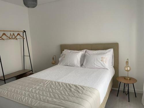 a bed with white sheets and pillows in a bedroom at Marinho's Oporto Apartments in Porto