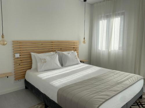 a bedroom with a large bed with a wooden headboard at Marinho's Oporto Apartments in Porto