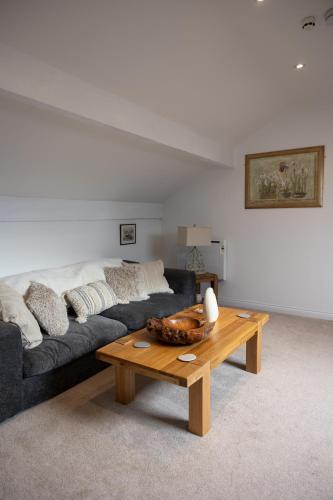 a living room with a couch and a coffee table at The Amazing Attik Apartment in Skipton