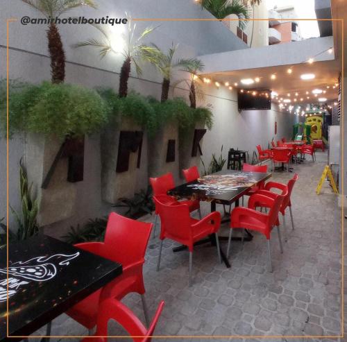 a restaurant with red chairs and a table and tables and chairs at Amir Hotel Boutique CA 