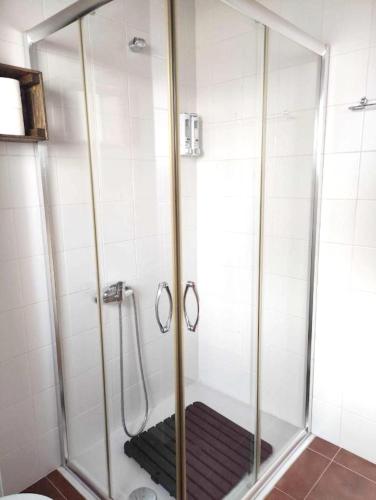 y baño con ducha y alfombra negra. en Charming House in Redondo + Air Conditioned, en Redondo