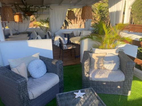 a patio with two wicker chairs and a table at Casa Doramas VV in Las Palmas de Gran Canaria