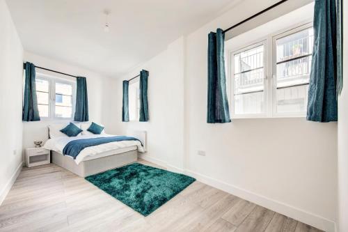 a white bedroom with a bed and a window at 2 bedroom apartment with large rooms and Wi-Fi in London