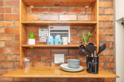 a wooden shelf with utensils on it at Blouberg Studio Apartments in Bloubergstrand