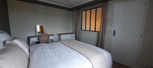 a bedroom with a white bed and a window at Résidences Privées appartements 1 ou 3 entre Varengeville sur mer & Dieppe in Hautot-sur-Mer