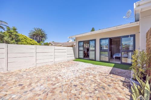 a house with a fence and a patio at Blouberg Studio Apartments in Bloubergstrand