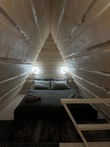 a room with a bed in the middle of a wall at A frame house Kryvorivnia in Verkhniy Yasenov