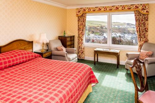 a hotel room with a red bed and a window at Fernhill Hotel in Portpatrick