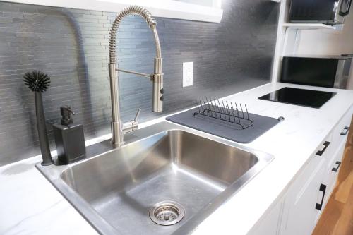 una cocina pequeña con fregadero de acero inoxidable en Cozy apartment in Ahuntsic with Free Parking and near metro station, en Montreal