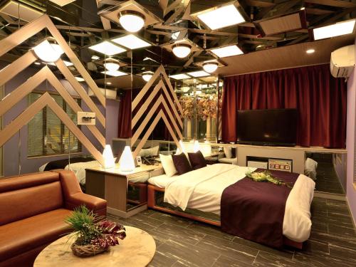 1 dormitorio con 1 cama, TV y sofá en HOTEL CHANT - Adult Only 大人専用, en Sakai