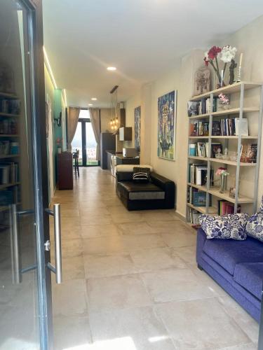 a living room with a couch and a table and bookshelves at La Macarena in Seville