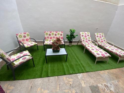 um quarto com quatro cadeiras e uma mesa num tapete verde em La Macarena em Sevilha