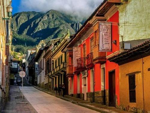 een lege straat met gebouwen en bergen op de achtergrond bij Beautiful Chalet In Bogota! in Bogota
