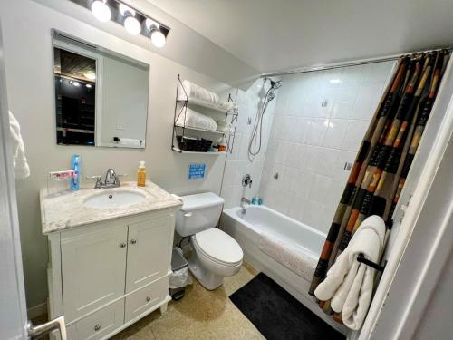een badkamer met een wastafel, een toilet en een bad bij Private spacious oversized suite with free parking in Kingston