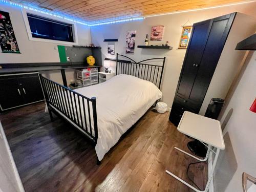 een kleine slaapkamer met een bed en een bureau bij Private spacious oversized suite with free parking in Kingston