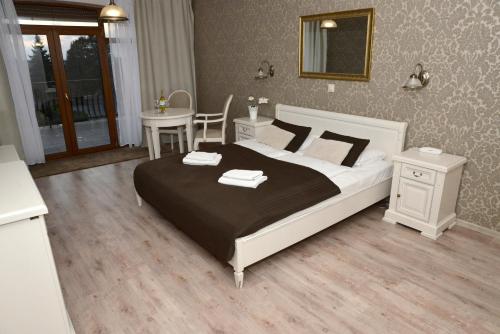 1 dormitorio con cama, mesa y escritorio en Hotel Magnat, en Słupca