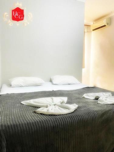 a bed with two white towels on top of it at Hotel Central Campo Grande in Campo Grande