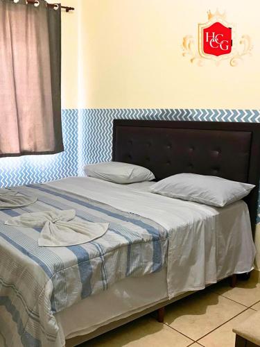 a bedroom with a bed with a blue and white blanket at Hotel Central Campo Grande in Campo Grande