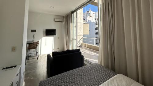 a bedroom with a bed and a view of a balcony at Marais Recoleta in Buenos Aires
