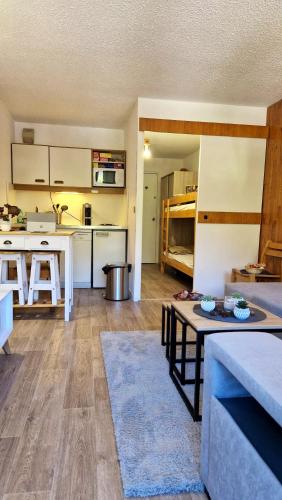 une cuisine et un salon avec un canapé et une table dans l'établissement Studio avec vue imprenable sur la montagne à Isola, 25 m²., à Isola