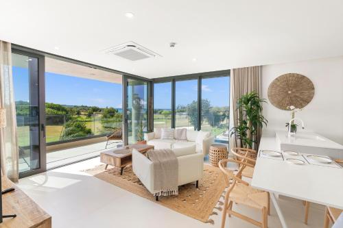 a living room with white furniture and large windows at Fourteen at Mullet Bay in Cupecoy
