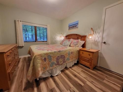 een slaapkamer met een bed, een dressoir en een raam bij Hidden Oasis Close to Beach and Town in South Haven