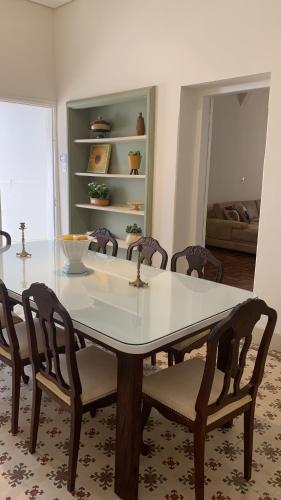 uma mesa de jantar com cadeiras e uma mesa branca em Hospedaria das Brotas em Espírito Santo do Pinhal