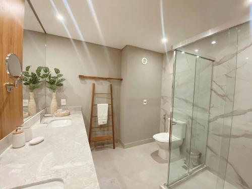 een badkamer met een glazen douche en een toilet bij Flat Île de Pipa Luxxor - By Almare in Pipa