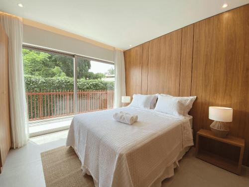 een slaapkamer met een groot bed en een raam bij Flat Île de Pipa Luxxor - By Almare in Pipa