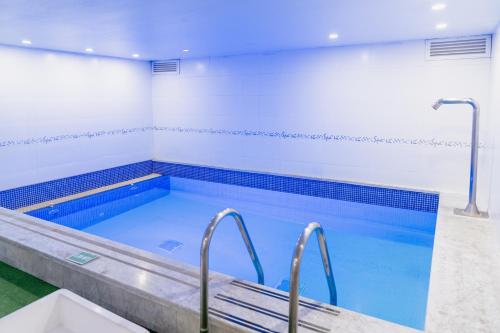 a large swimming pool with blue water at Hotel 101 Park House in Bogotá