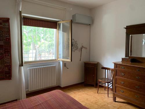 レッチェにあるVilla Margheritaの窓付きのベッドルーム、椅子、ドレッサーが備わります。