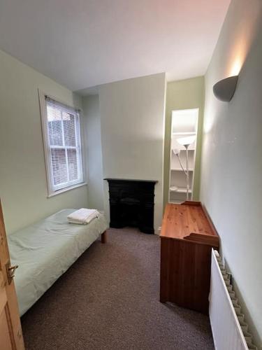 a bedroom with a bed and a desk and a mirror at 3 Bed Ground Floor Flat in London