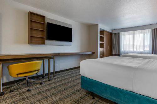 a hotel room with a bed and a desk and a tv at MainStay Suites Coeur d'Alene in Coeur d'Alene