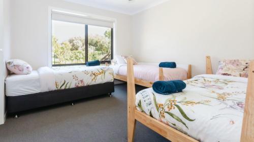 a bedroom with three bunk beds and a window at Cape Retreat in Cape Schanck