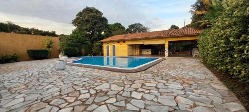 een zwembad in de tuin van een huis bij Casa de Campo Acolhedora e Confortável in Ribeirão Preto