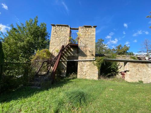 an old brick building on a grass field at Gli ulivi Gualdo Tadino Uniquement de samedi à samedi Lits pour 10 personnes in Pieve di Compresseto