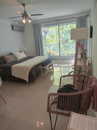 ein Schlafzimmer mit einem Bett, einem Stuhl und einem Fenster in der Unterkunft Be Happy Studio Palermo Soho in Buenos Aires