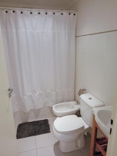 a white bathroom with a toilet and a sink at Be Happy Studio Palermo Soho in Buenos Aires