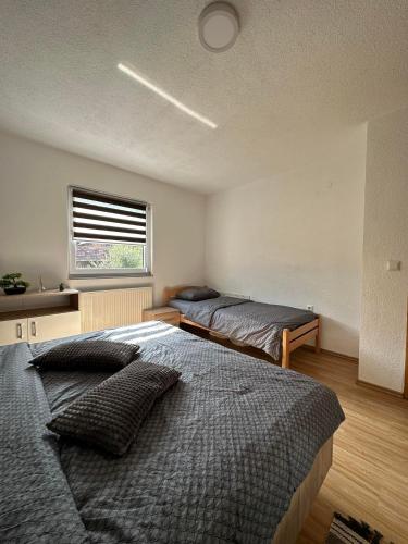 a bedroom with two beds and a window at Kamenice soba L in Jajce
