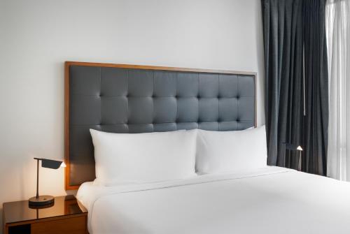 a bedroom with a large bed with a black headboard at Level Los Angeles - Downtown South Olive in Los Angeles