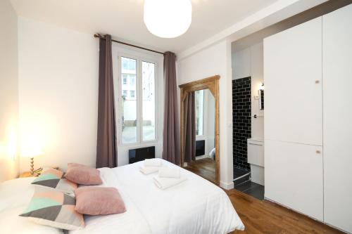 - une chambre avec un lit blanc et des oreillers dans l'établissement Pick A Flat's Apartment in Bastille - Rue Mornay, à Paris