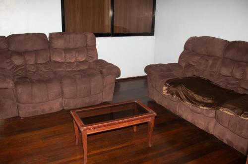 a living room with two couches and a coffee table at Hotel Colonial in Puyo
