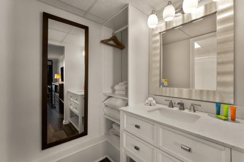 een witte badkamer met een wastafel en een spiegel bij Atlantic Oceanside Dewey in Dewey Beach