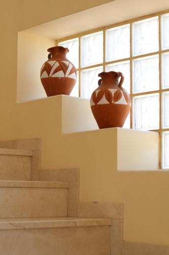 two vases sitting on a shelf in front of a window at Villa Clairol in Los Gallardos